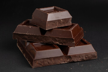 Pieces of dark chocolate on a dark background