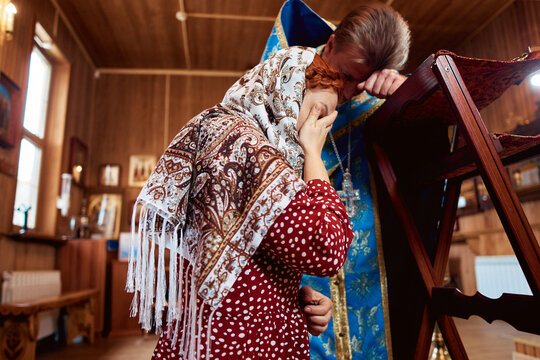 a woman repents of her sins, confessions with a priest in an Orthodox church