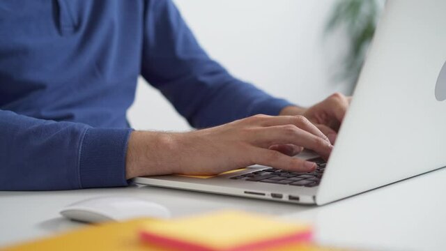 Close-up of man typing on laptop