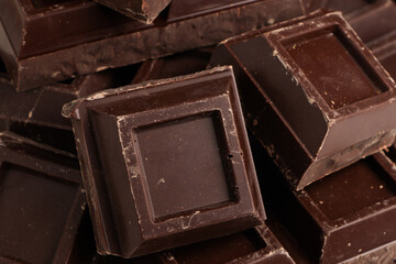 Broken pieces of dark chocolate close up