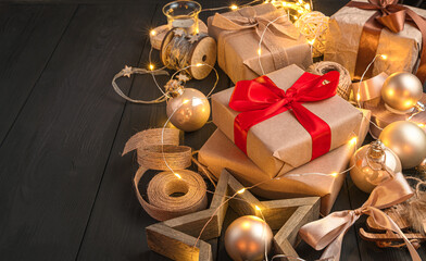 Christmas gifts and decorations on a black background. Side view, copy space.