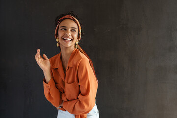 Young hispanic woman in earrings laughing and looking aside