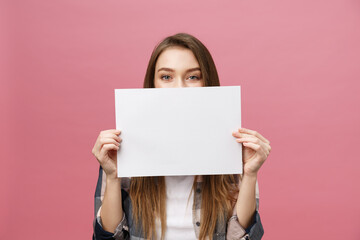 Young caucasian woman holding blank paper sheet over isolated background scared in shock with a...
