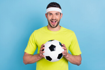 Photo of amazed excited cheerful man hold hand football game play championship isolated on blue...