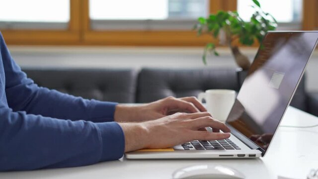 Close-up of programmer writing code on laptop