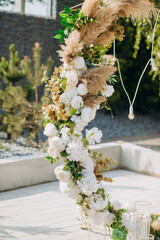 The round arch is decorated with flowers and dried flowers. Details of the wedding ceremony