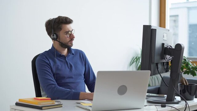 Young man programmer working on computer at small office