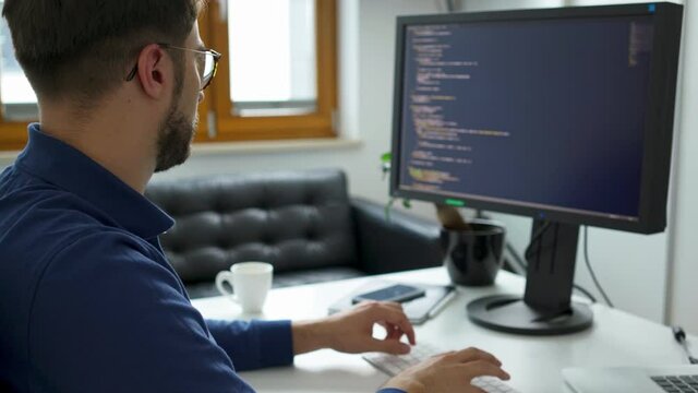 Computer programmer working on computer writing code
