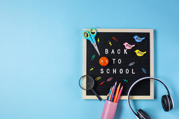Flat lay of back to school concept on blue background with copy space