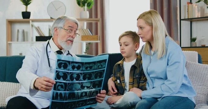 Healthcare concept where likable confident skilled bearded doctor visiting patients at home and discussing with them results of x-ray scan ,close up