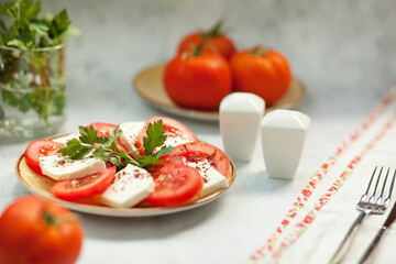 
Red tomatoes with mozzarella cheese on a served table. Healthy breakfast.