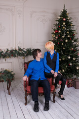 young couple in love at home on Christmas tree on background