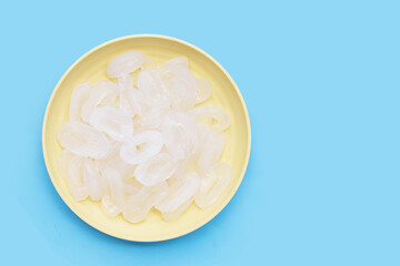 Toddy palm slices in yellow plate on blue background.