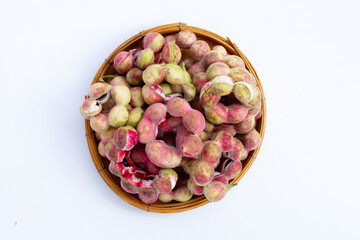 Manila tamarind fruit in bamboo basket on white background
