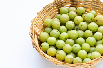 Fresh emblica in bamboo basket on white background.