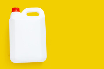 Blank packaging white plastic gallon on yellow background.