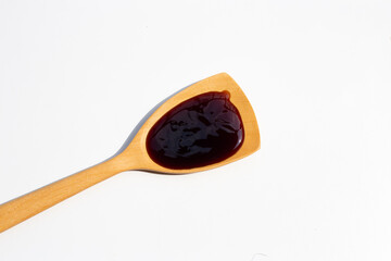 Oyster sauce in wooden spatula on white backgroound.