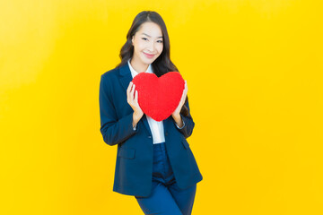 Portrait beautiful young asian woman smile with heart pillow shape