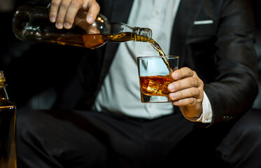 Closeup businessmen holding a glass of whiskey