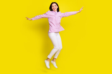 Fototapeta na wymiar Full length body size view of attractive funny cheery girl jumping having fun free isolated over bright yellow color background