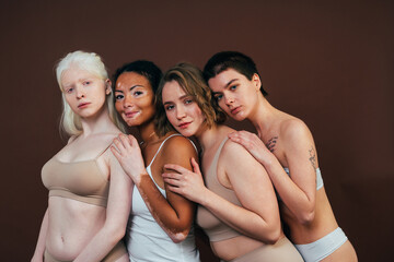 Group of multiethnic women with different kind of skin posing together in studio. Concept about...