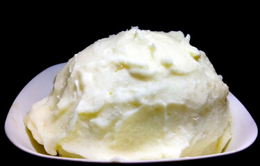 Bowl of butter isolated on black background