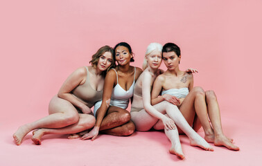 Group of multiethnic women with different kind of skin posing together in studio. Concept about...