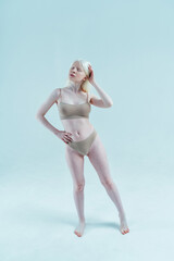 Beauty image of an albino girl posing in studio wearing lingerie. Concept about body positivity, diversity, and fashion