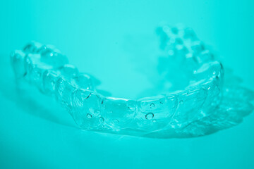 Invisible dental teeth brackets tooth aligners on blue background. Plastic braces dentistry...