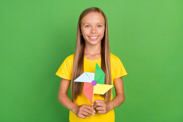 Portrait of attractive cheerful long-haired girl holding fan eco energy isolated over vibrant green...