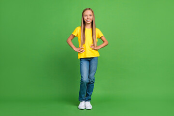 Full length body size view of attractive cheerful girl posing hands on hips isolated over bright green color background