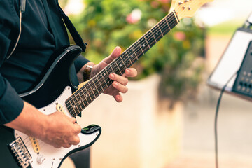 Obraz premium Close up view of a musician playing a electric guitar in a live concert outdoors