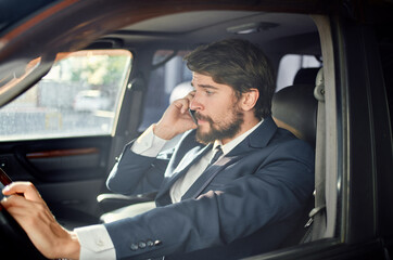 emotional man in a suit in a car a trip to work communication by phone