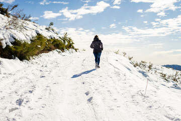 Fototapeta na wymiar Young traveler woman jogging on snowed mountain