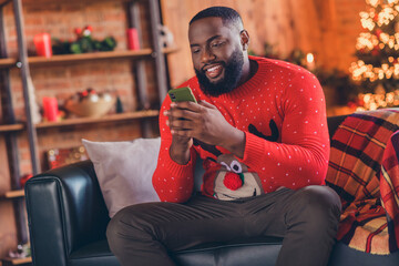 Photo of young black man happy positive smile look read browse cellphone post blogger x-mas noel...