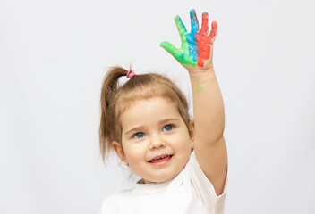 beautiful little girl with her hands in the paint