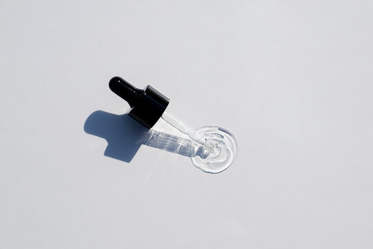 Open cap with dropper pipette with serum. Light background with daylight and the appearance of the texture of the gel.Skincare products , natural cosmetic. Beauty concept for face and body care