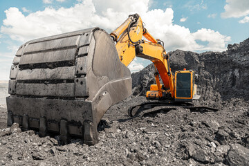 Large quarry dump truck. Big yellow mining truck at work site. Loading coal into body truck....