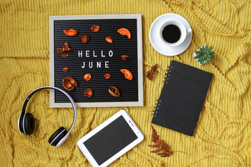 Hello June written on the letter board with multimedia and gadget accessories flat lay concept