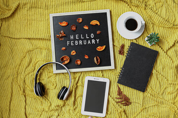 Hello February written on the letter board with multimedia accessories and coffee flat lay concept