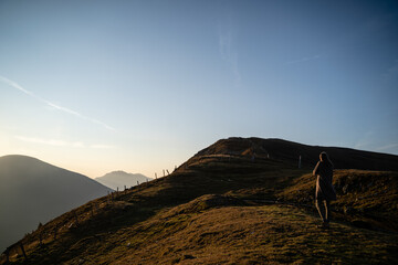 Junge Frau fotografiert nach Wanderung bei Sonnenaufgang am Berg in Salzburg Österreich