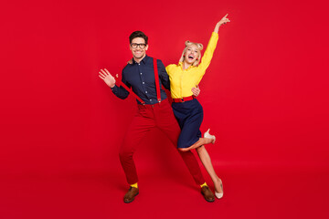 Full length body size view of trendy cheerful ecstatic funky couple dancing having fun isolated over bright red color background