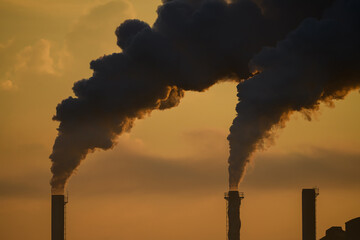Industrial scene with high smoke stack with smoke emission.