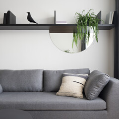 Cozy gray sofa and shelf with decorations, close-up