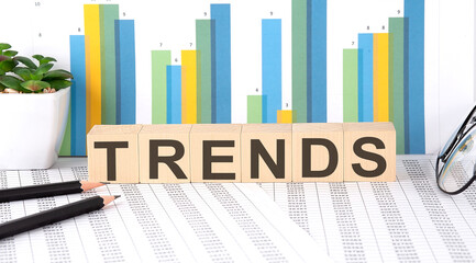 TRENDS word written on wood block with chart, glasses and pencils