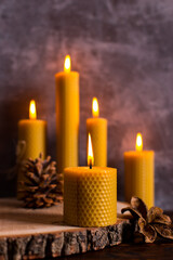 A handmade of natural wax with texture of honeycomb bees candles burns on the table, an unusual element of the interior.