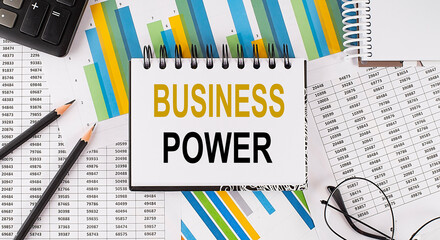 Closeup a notebook with text BUSINESS POWER , business concept image on chart background