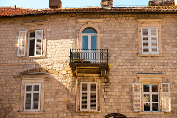Windows with shutters on an old stone house, old architecture.