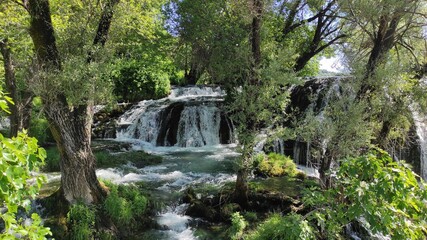 Fototapeta na wymiar View of a beautiful waterfall in a garden in the south of Bosnia and Herzegovina.