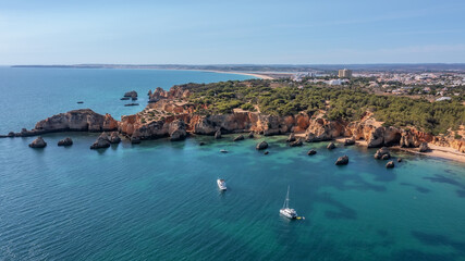 Fototapeta na wymiar Beautiful seascape from the air, paradise bay with a yacht, Portuguese beaches, algarve.